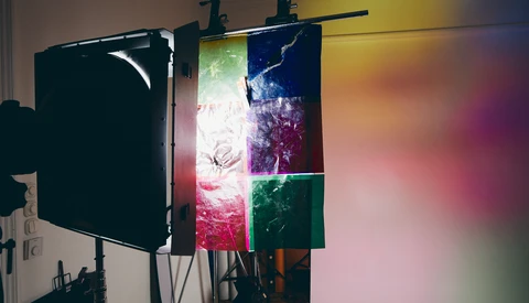 Professional lighting setup with black flag reflector and multicolored LED panels mounted on a rigging system.