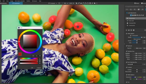 Screenshot of color grading software showing a portrait of a smiling person surrounded by citrus fruits on a green background.