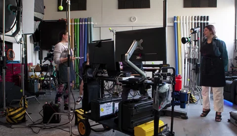 Film production crew operating professional cinema camera equipment on a studio set.