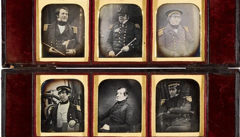 Collection of 14 daguerreotypes arranged in a wooden case with red velvet lining.