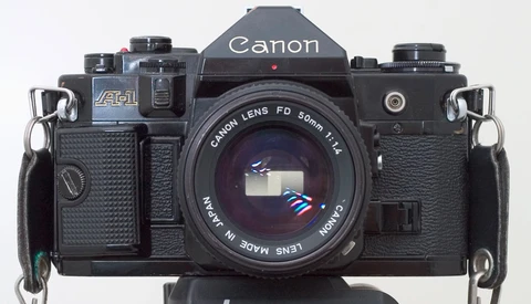 Canon F-1 35mm SLR camera with Canon FD 50mm f/1.4 lens mounted, shown from front against white background.