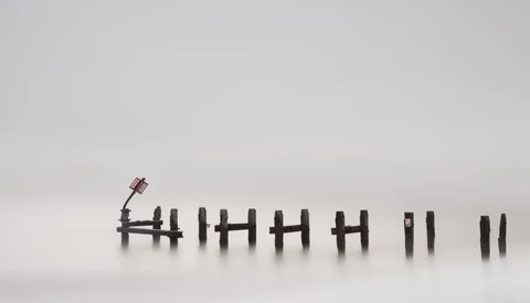 Tally marks etched into snow with a small figurine standing at the leftmost mark.
