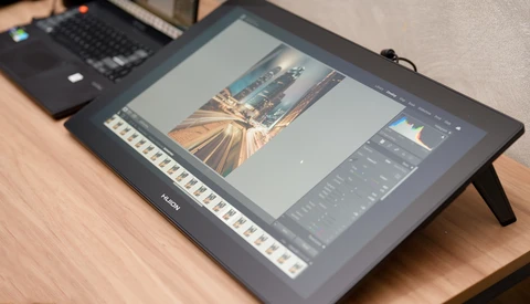Editing display tablet showing photo of architectural golden hour scene with editing panels open.