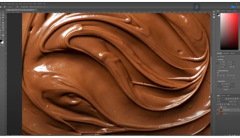 Close-up of swirled chocolate texture with glossy highlights and smooth peaks.