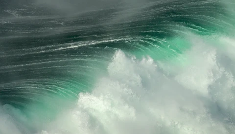 Dramatic ocean wave with turquoise water and white foam captured mid-break.