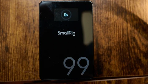 SmallRig 99 portable power station displaying 0x charge status on wooden surface.