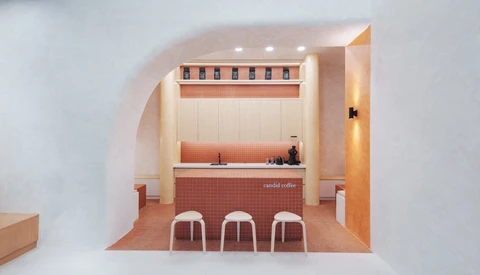 Interior rendering of a minimalist coffee shop with terracotta tile flooring and three white stools at the counter.