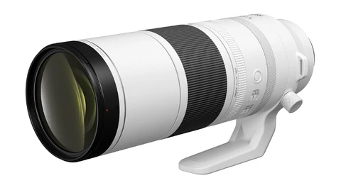 White telephoto lens with black front element and focus ring, shown at three-quarter angle against white background.