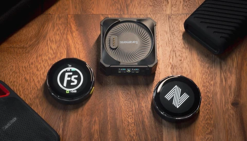 Three circular lens filters and a square camera cooling device arranged on a wooden surface.