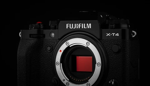Fujifilm X-T4 mirrorless camera body with open sensor mount against black background.