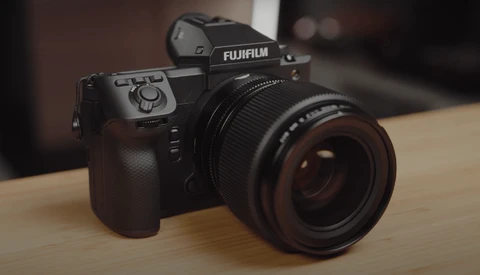 Fujifilm GFX medium format camera with attached lens on wooden surface.