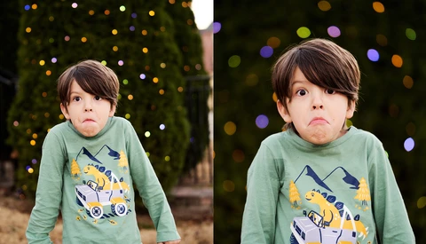 Young child with serious expression wearing green long-sleeve shirt with graphic design, photographed against blurred bokeh background.