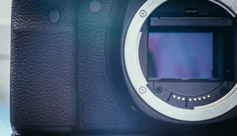 Camera body with open mirror box revealing sensor and internal mechanics.