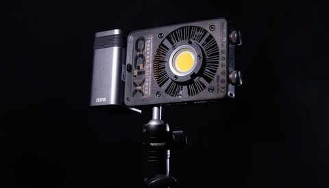Professional LED light fixture mounted on a studio stand against a black background.
