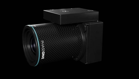 Hasselblad modular camera system with carbon fiber lens and digital back against black background.