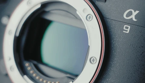 Close-up of a mirrorless camera body showing the open lens mount with visible sensor and electronic contacts.