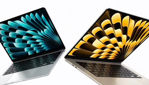 Two open laptops displaying colorful geometric feather wallpapers in turquoise and gold tones.