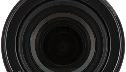 Close-up view of concentric lens elements receding into darkness, showing the optical barrel of a camera lens.