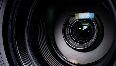 Close-up view of camera lens elements and aperture blades with internal reflections.