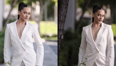 Woman in white blazer photographed outdoors during daytime with natural lighting and blurred foliage background.