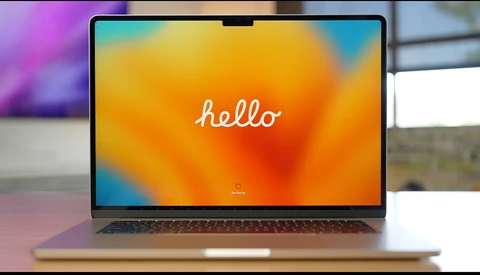 Laptop displaying a colorful gradient wallpaper with the word "hello" in white script text.