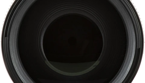 Close-up view into the barrel of a camera lens showing concentric glass elements and internal aperture mechanism.