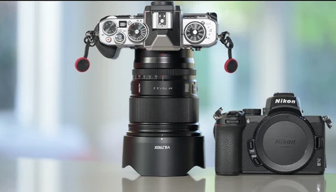 Vintage rangefinder camera mounted on lens assembly above modern Nikon mirrorless camera body.