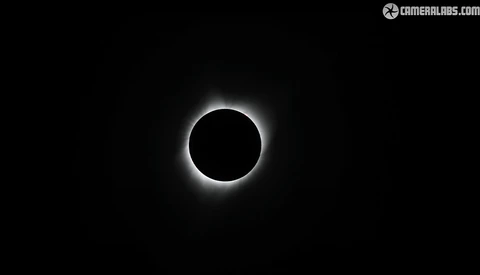 Total solar eclipse with the moon blocking the sun and corona visible as a bright halo against a black sky.