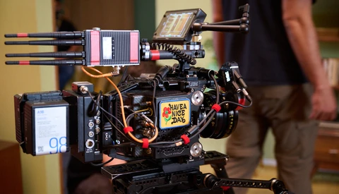 Compact cinema camera rig with mounted monitor, wireless follow focus, and professional accessories on support frame.