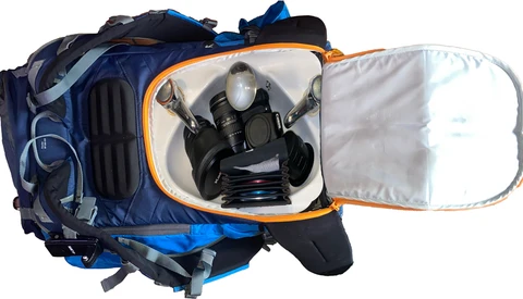 Open camera bag with protective dividers displaying a gas mask and breathing apparatus inside.