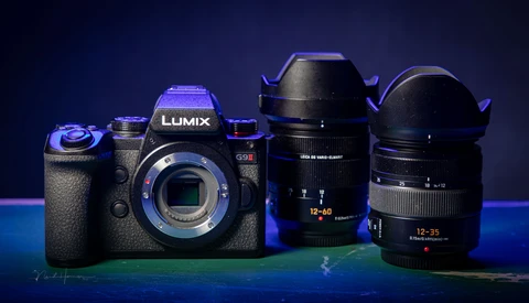 Panasonic Lumix G9II camera body with two interchangeable lenses arranged on a blue-lit surface.