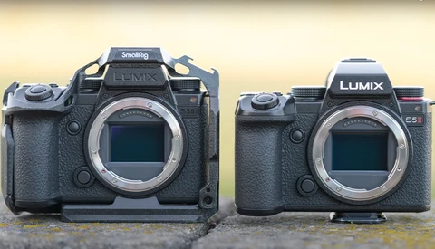 Panasonic Lumix S5II camera body next to a Smallrig-rigged camera of larger format on concrete surface.
