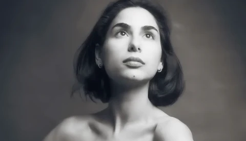 Black and white portrait of a woman with shoulder-length dark hair, looking upward with a contemplative expression.