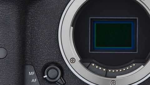 Close-up of a camera's mirror and sensor chamber with autofocus controls visible on the body.