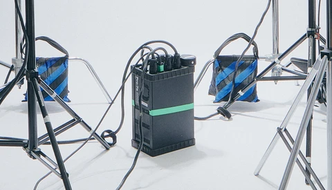Three 3D printers with blue filament spools arranged on a white surface against a neutral background.