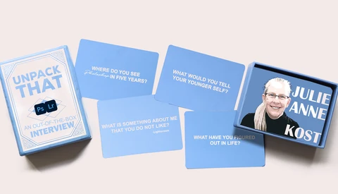 Unpack That interview card deck with blue question cards and a portrait card featuring Julie Anne Kost.