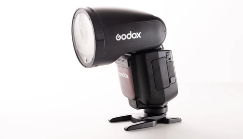 Godox speedlight flash with reflector attachment and stand foot against white background.