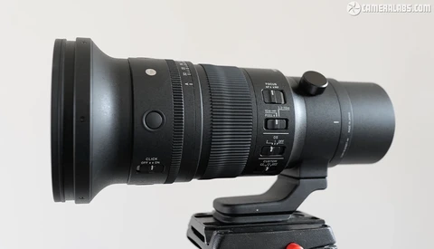 Telephoto lens with focus ring and aperture controls mounted on tripod head.