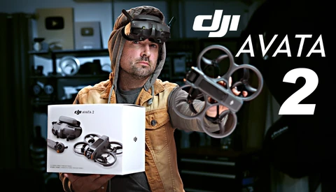 Person wearing FPV goggles and tan jacket holds DJI Avata 2 drone packaging while displaying the assembled quadcopter.