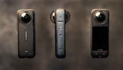 Three compact digital video cameras displayed front and side views against a textured gray background.