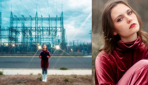 Young woman in burgundy velvet standing before an industrial steel structure with dramatic lighting effects.