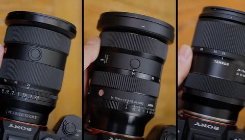 Three Sony camera lenses displayed side-by-side against a wooden background, showing barrel details and focal length markings.