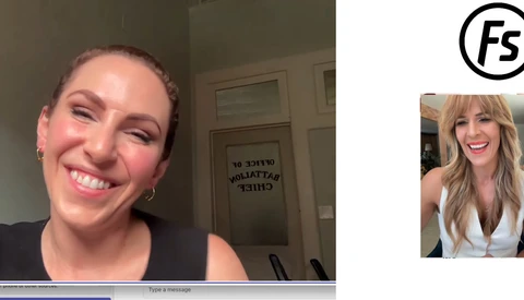Woman smiling at camera during a video call, wearing black sleeveless top with gold hoop earrings.