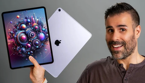 Man holding iPad displaying vibrant digital artwork of colorful mechanical gears and spheres.