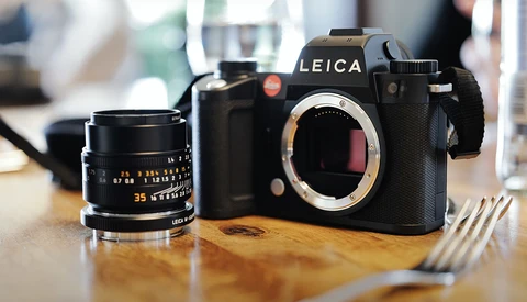 Leica SL2 camera body with 35mm lens on wooden surface.