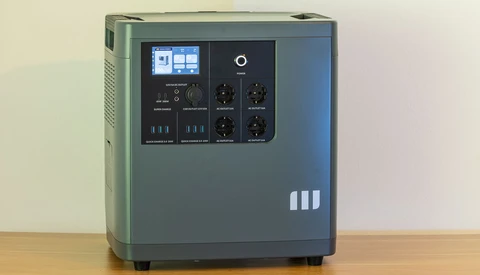 Portable power station with digital display and control panel on wooden surface.