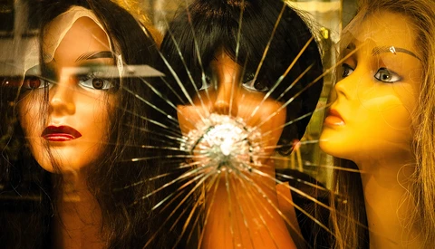 Two women's faces flanking a shattered glass center with radiating light rays.