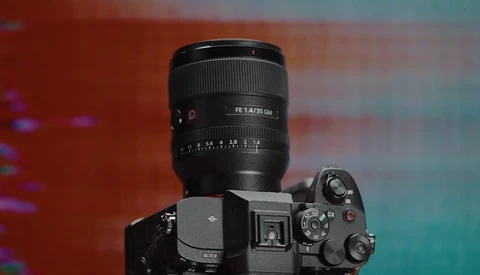 Sony mirrorless camera with FE 1.4/35 GM lens mounted against warm and cool gradient backdrop.