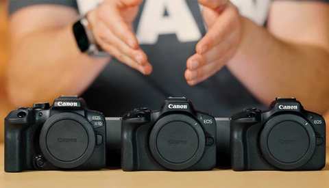 Three Canon EOS DSLR camera bodies arranged in a row, shown from the front with a person holding an 'A' card above them.