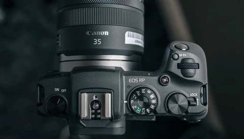 Canon EOS RP camera with Canon 35mm lens mounted, viewed from above showing top plate controls and hot shoe.